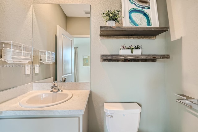 bathroom featuring toilet and vanity