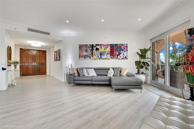 living room featuring light wood-type flooring and crown molding