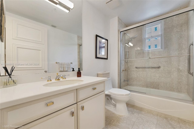 full bathroom with tile patterned floors, vanity, toilet, and shower / bath combination with glass door