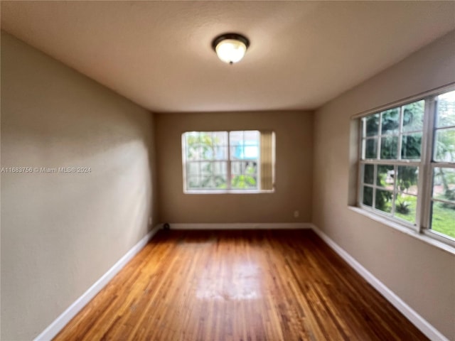 empty room with hardwood / wood-style floors and plenty of natural light