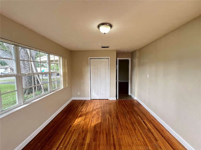 unfurnished bedroom featuring hardwood / wood-style flooring and a closet