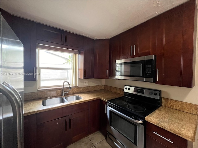 kitchen with sink, light tile patterned floors, and stainless steel appliances