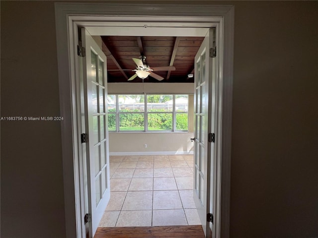 hallway featuring beamed ceiling, french doors, wooden ceiling, and light tile patterned floors