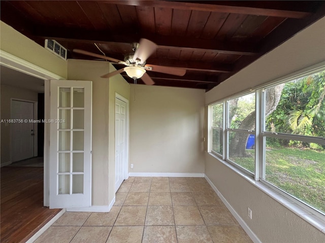 unfurnished sunroom featuring beamed ceiling, wooden ceiling, and ceiling fan