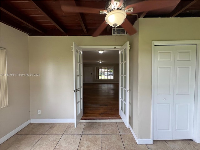 hall with french doors, light tile patterned floors, wooden ceiling, and beam ceiling