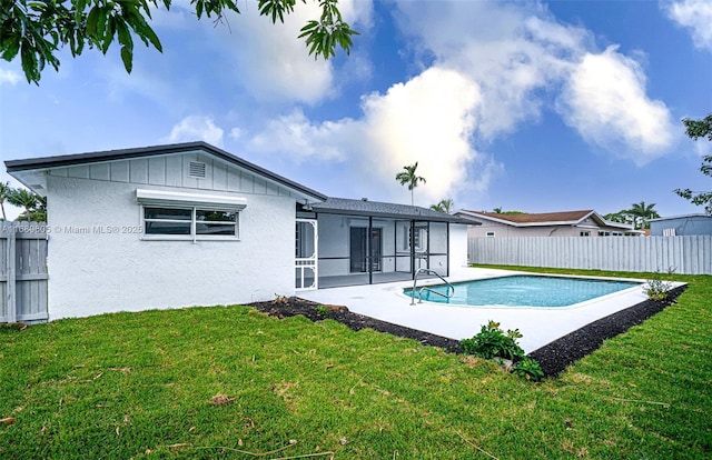 back of house featuring a yard, a fenced in pool, and a patio area