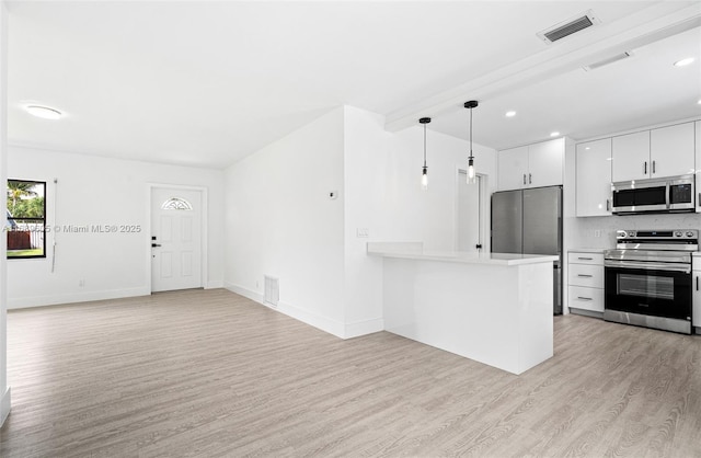 kitchen featuring kitchen peninsula, light hardwood / wood-style flooring, hanging light fixtures, white cabinets, and appliances with stainless steel finishes