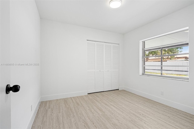 unfurnished bedroom with a closet and light hardwood / wood-style flooring