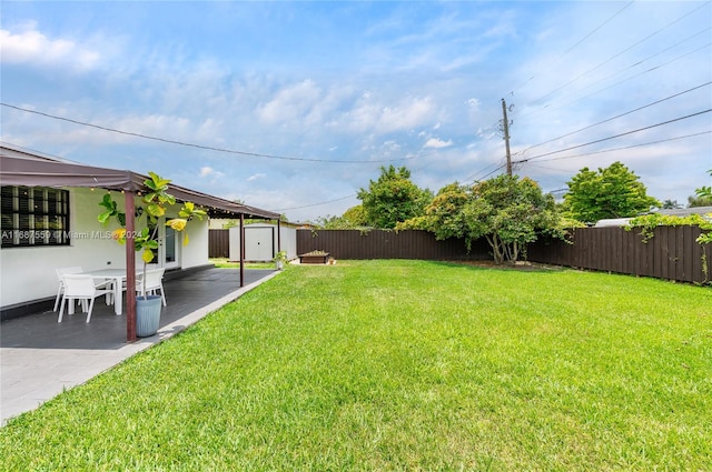 view of yard with a storage shed and a patio area