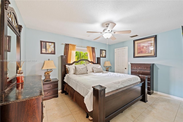 bedroom with a textured ceiling, ceiling fan, and light tile patterned flooring