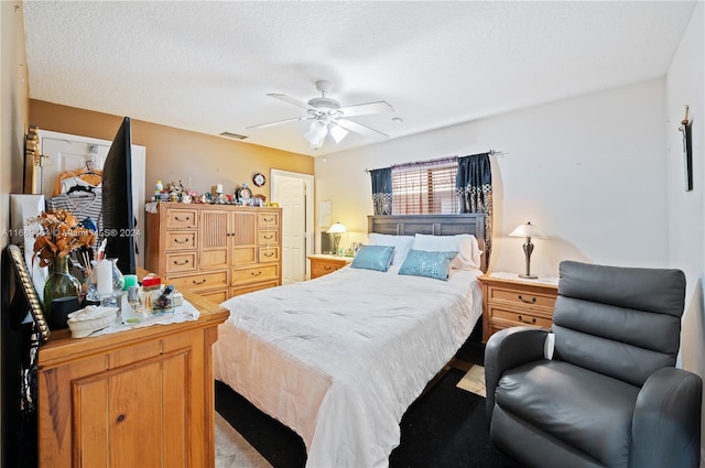 bedroom with ceiling fan, a textured ceiling, and light carpet