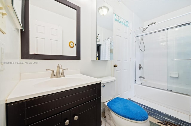 full bathroom featuring enclosed tub / shower combo, toilet, and vanity