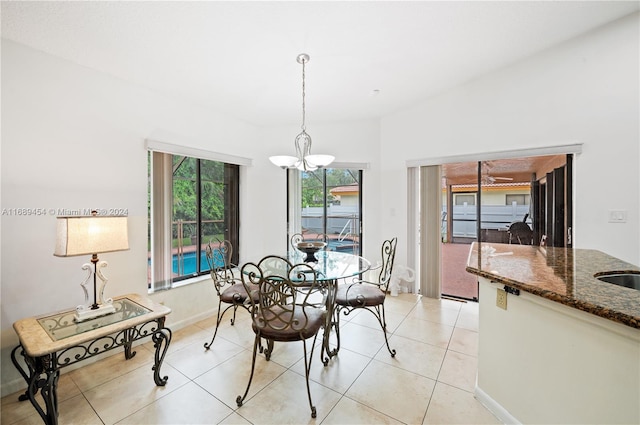 tiled dining room with a chandelier and vaulted ceiling