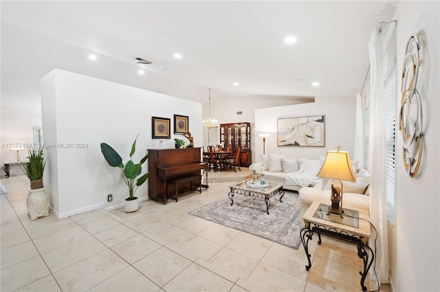 living room featuring light tile patterned flooring, a chandelier, and vaulted ceiling