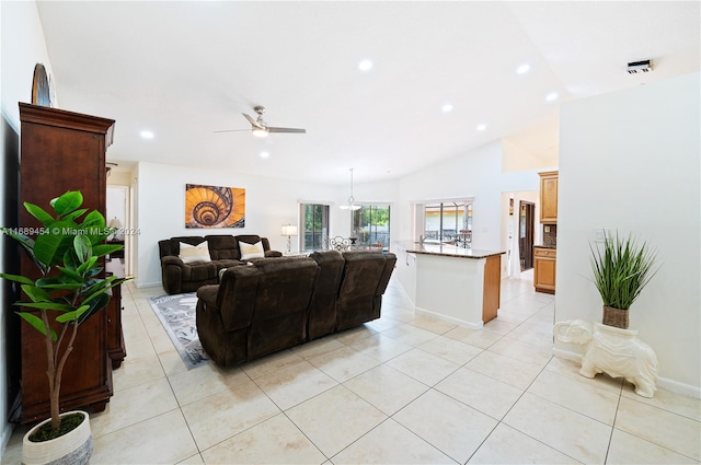 living room with lofted ceiling, light tile patterned floors, and ceiling fan