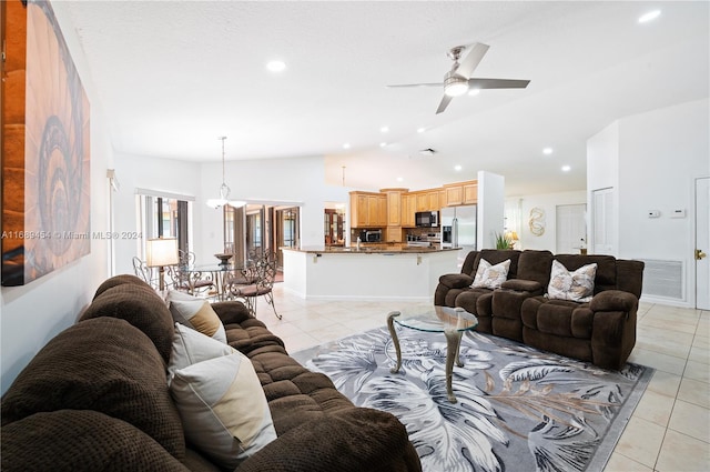 living room with lofted ceiling, light tile patterned flooring, and ceiling fan with notable chandelier