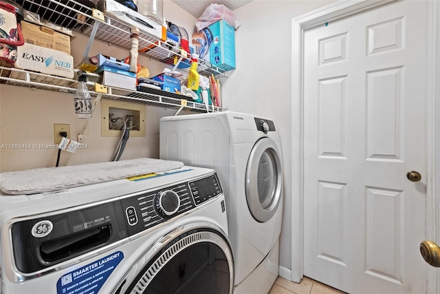 washroom with independent washer and dryer and light tile patterned floors