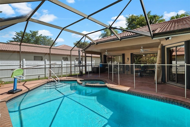 view of swimming pool featuring glass enclosure, a patio area, ceiling fan, and an in ground hot tub