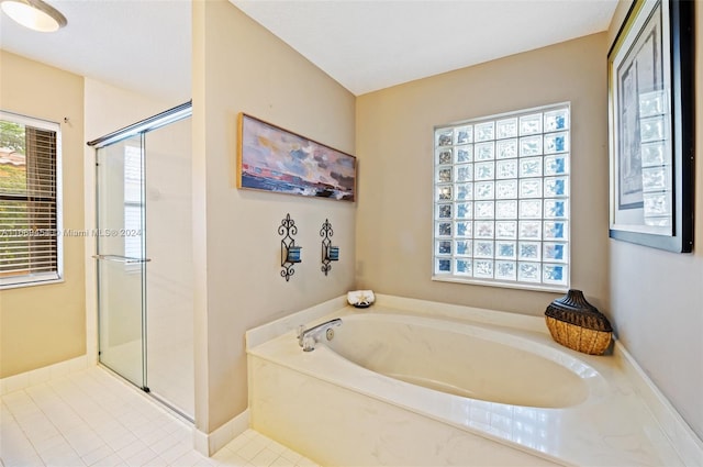 bathroom with a wealth of natural light, tile patterned flooring, and separate shower and tub