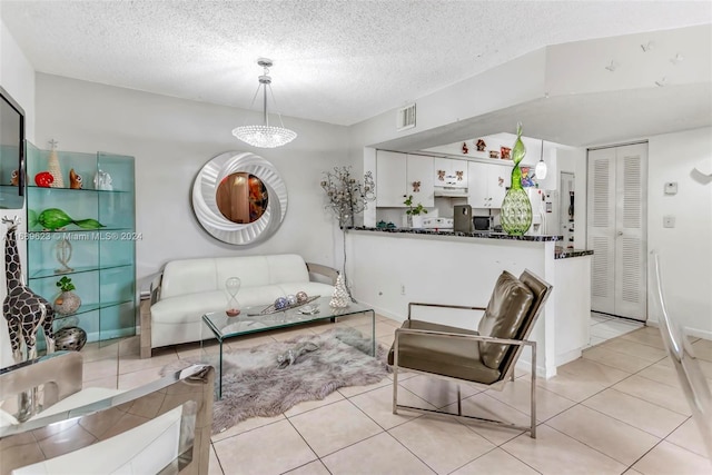 living room featuring a textured ceiling, a notable chandelier, and light tile patterned flooring