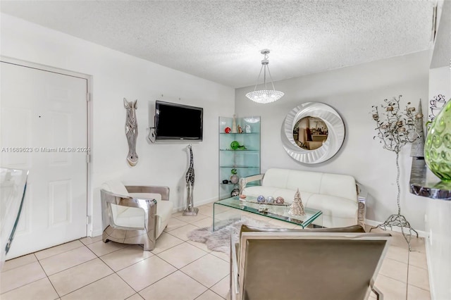 living room featuring a textured ceiling, light tile patterned floors, and a notable chandelier