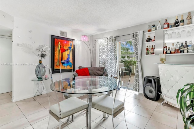 dining room with a textured ceiling and light tile patterned floors