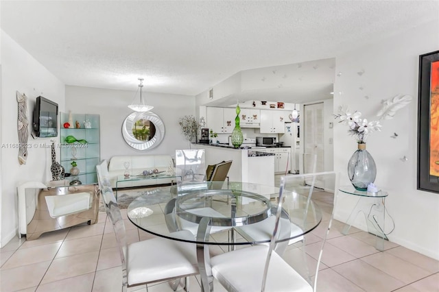 dining space featuring a textured ceiling and light tile patterned floors