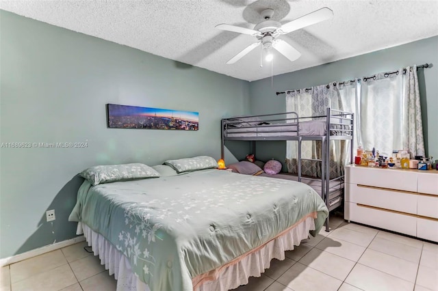 bedroom with a textured ceiling, light tile patterned floors, and ceiling fan