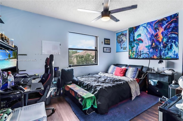 bedroom with dark wood-type flooring, ceiling fan, and a textured ceiling