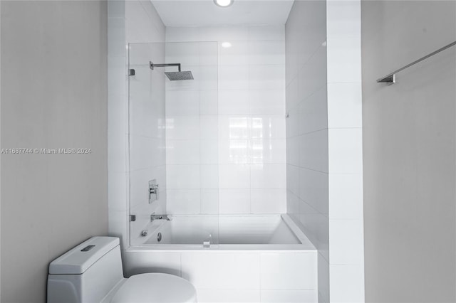 bathroom featuring tiled shower / bath and toilet