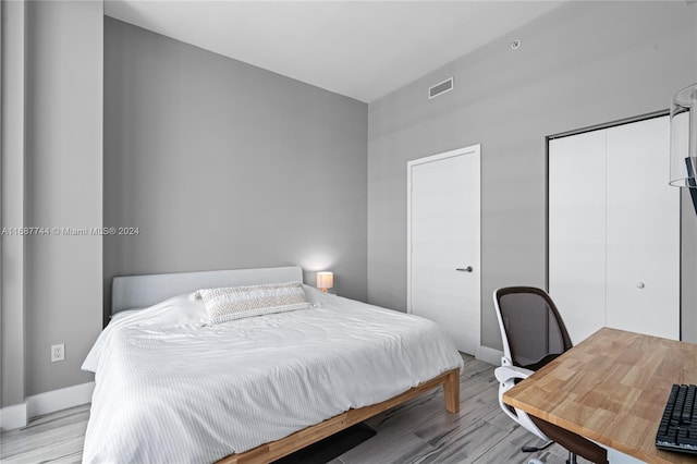 bedroom featuring light wood-type flooring and two closets