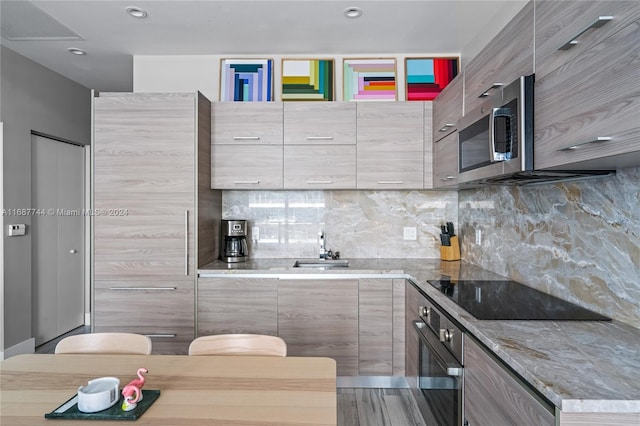 kitchen with decorative backsplash, appliances with stainless steel finishes, and light stone countertops