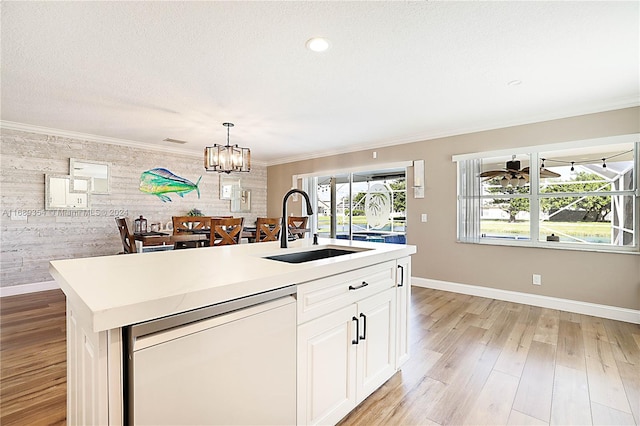 kitchen featuring white cabinetry, sink, white dishwasher, a kitchen island with sink, and crown molding