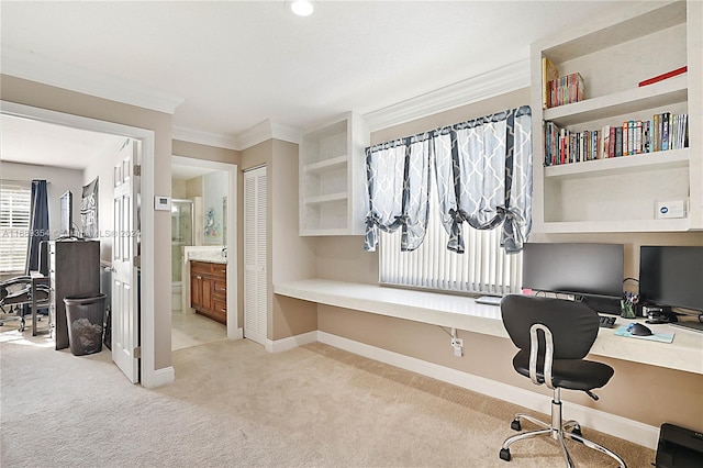 home office with built in desk, light carpet, and crown molding