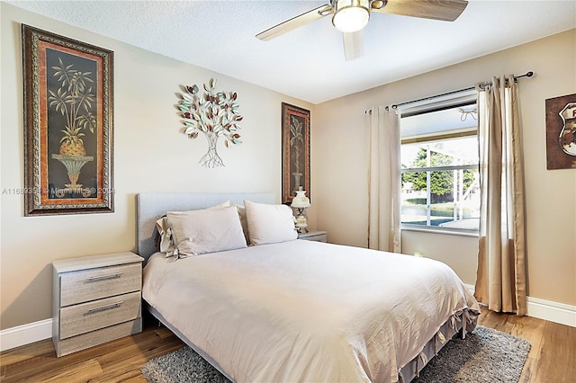 bedroom featuring a textured ceiling, light hardwood / wood-style flooring, and ceiling fan