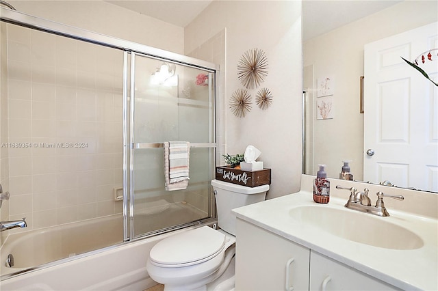 full bathroom featuring bath / shower combo with glass door, vanity, and toilet