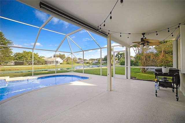 view of swimming pool featuring glass enclosure, a patio area, a yard, and a water view