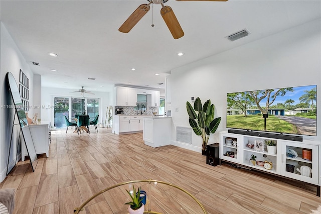 living room with sink and light hardwood / wood-style flooring