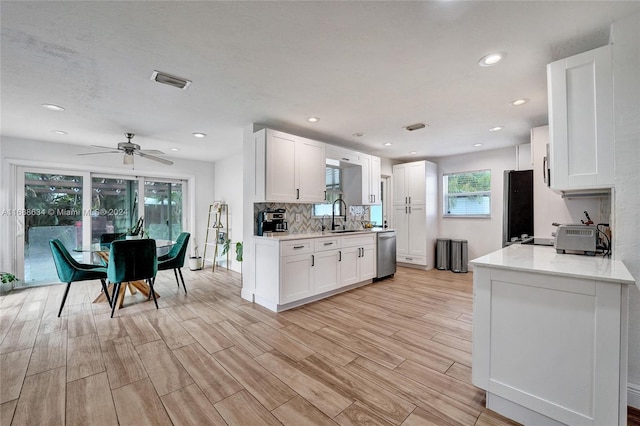 kitchen with white cabinetry, stainless steel appliances, and light hardwood / wood-style flooring