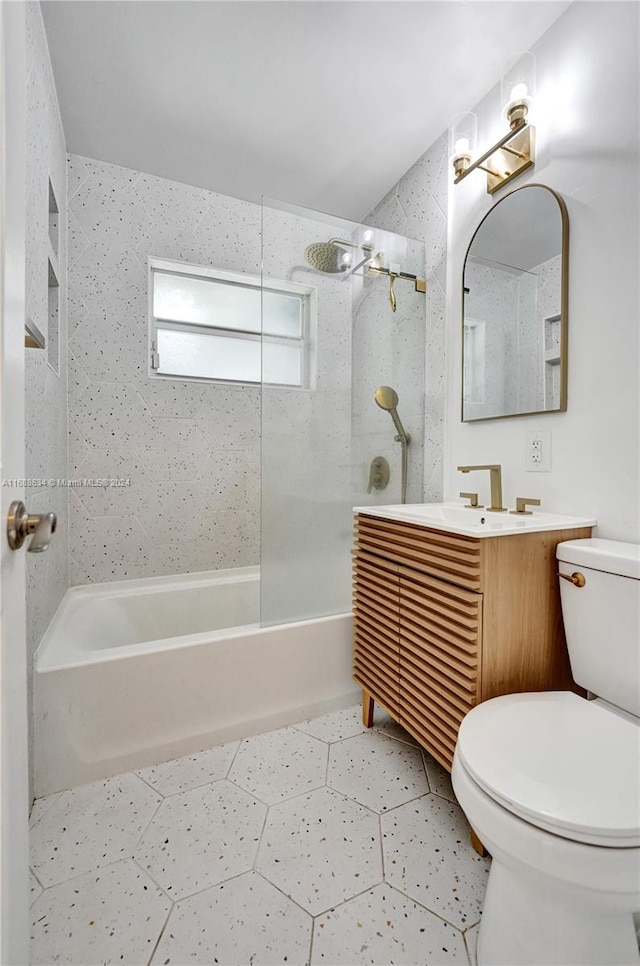 full bathroom featuring vanity, tiled shower / bath, and toilet