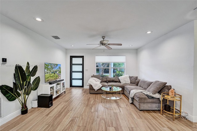 living room with light hardwood / wood-style floors and ceiling fan