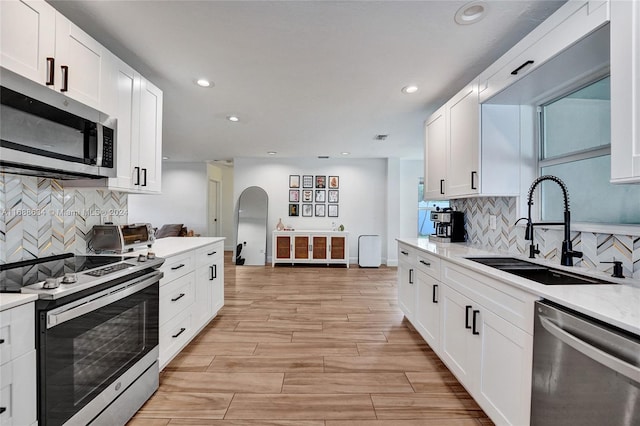 kitchen with white cabinets, light stone countertops, sink, and appliances with stainless steel finishes