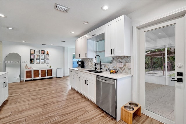 kitchen with dishwasher, light hardwood / wood-style flooring, white cabinetry, and sink