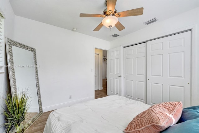 bedroom with hardwood / wood-style floors, ceiling fan, and a closet