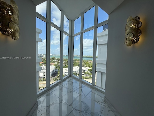 doorway with expansive windows and a water view