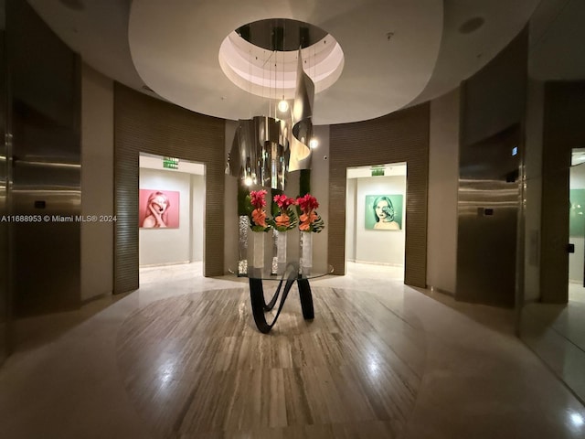 hallway featuring wood-type flooring, brick wall, and a tray ceiling