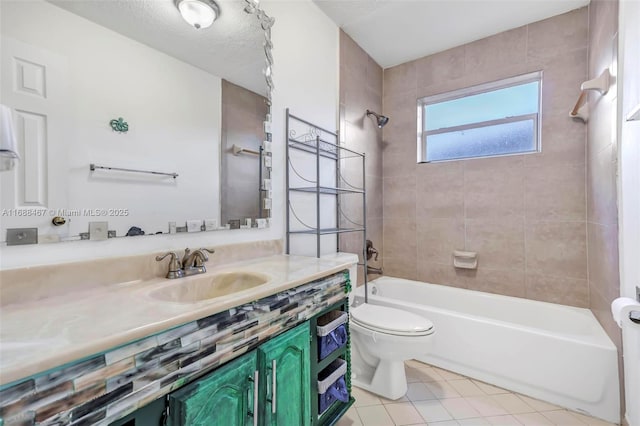 full bathroom with tile patterned floors, a textured ceiling, vanity, tiled shower / bath combo, and toilet