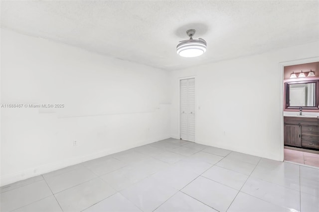 tiled spare room with a textured ceiling