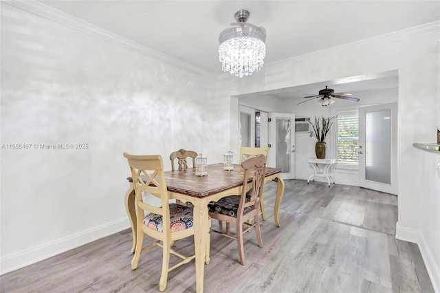 dining area featuring ceiling fan with notable chandelier, wood-type flooring, and crown molding