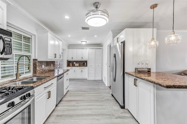 kitchen with sink, dark stone counters, decorative backsplash, white cabinets, and appliances with stainless steel finishes